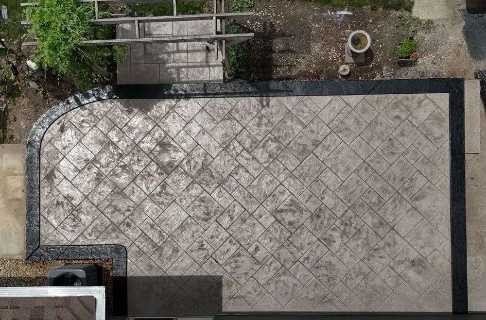 Stamped concrete slab framed by a smooth dark border band