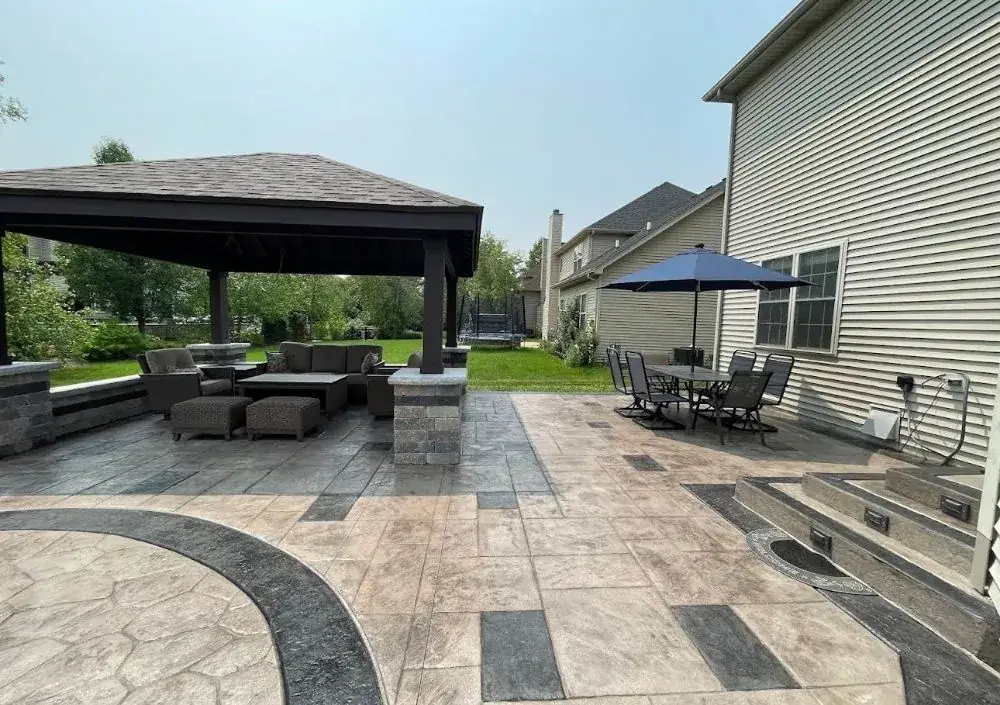 Stamped concrete patio with dark accent bands under a covered pavilion