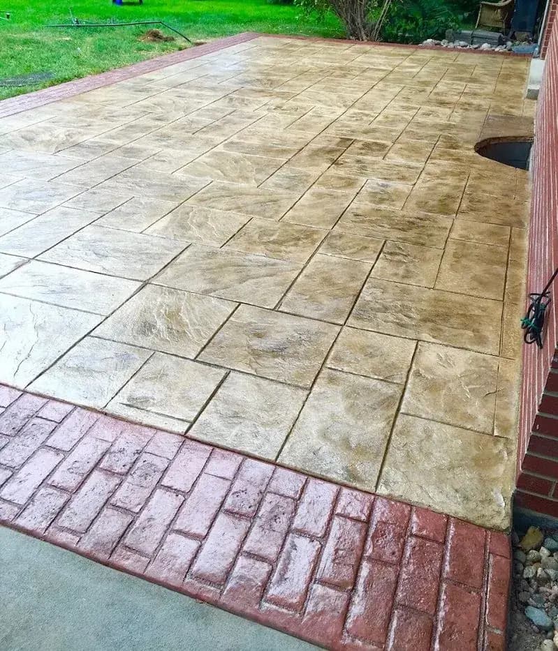 Ashlar slate stamped concrete patio with a red brick-pattern border